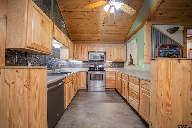 kitchen with appliances with stainless steel finishes, vaulted ceiling, light brown cabinetry, and sink