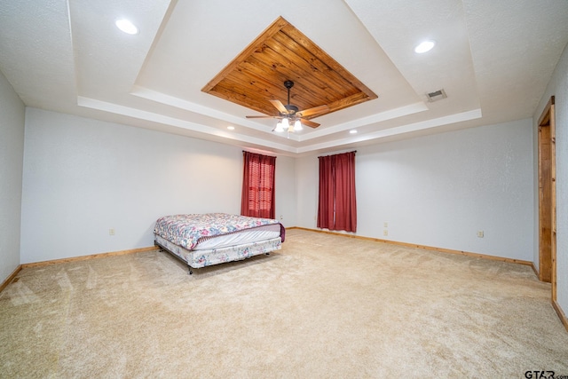 bedroom featuring a tray ceiling, ceiling fan, and carpet flooring