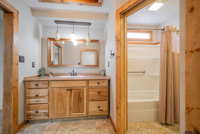 bathroom featuring shower / bath combo with shower curtain, vanity, and a textured ceiling