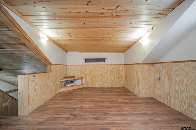 bonus room with a skylight, wood walls, wood ceiling, and hardwood / wood-style flooring