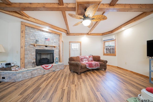 living room with a fireplace, hardwood / wood-style floors, a wall mounted air conditioner, and ceiling fan