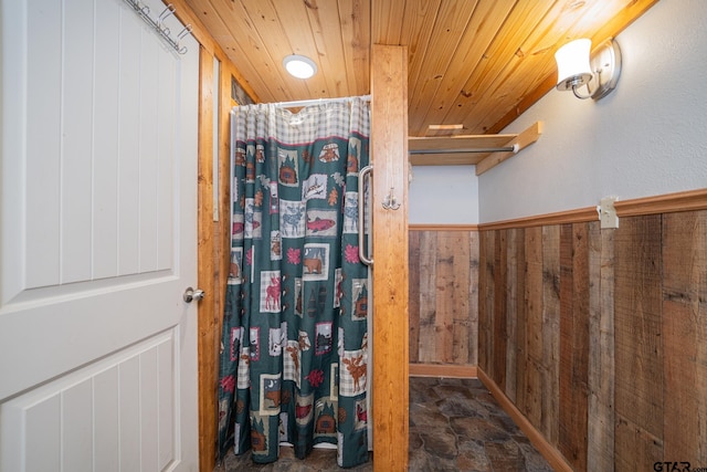 bathroom with wooden walls and wood ceiling