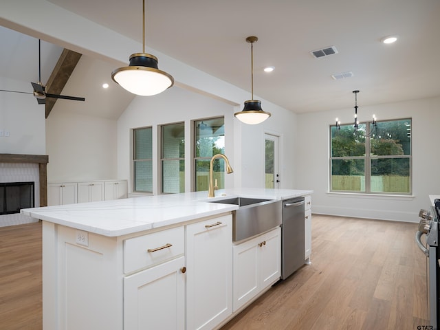 kitchen with white cabinets, a kitchen island with sink, a healthy amount of sunlight, and stainless steel appliances