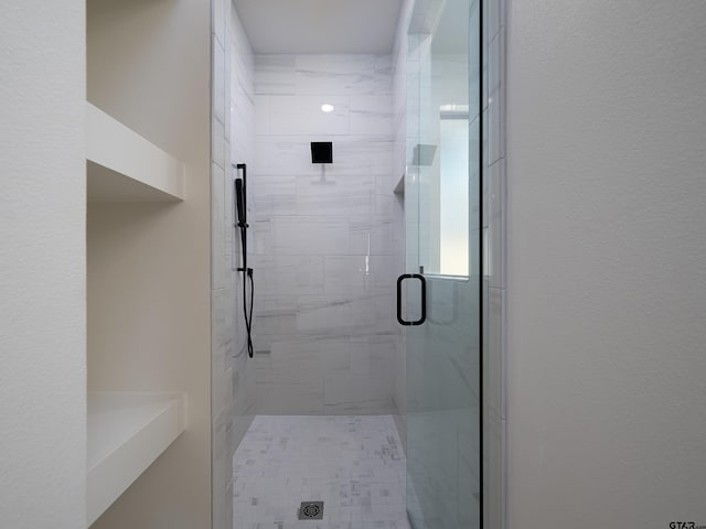 bathroom featuring a shower with shower door