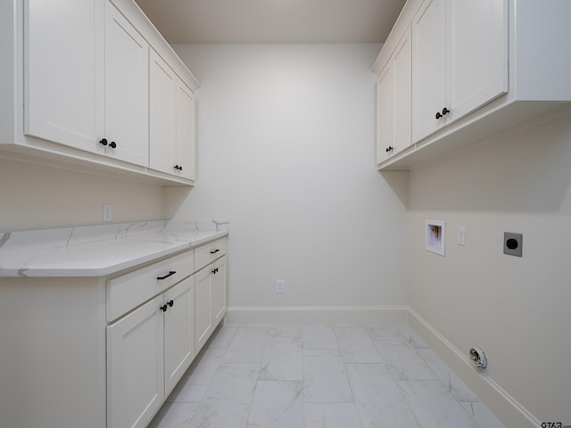 laundry area with hookup for an electric dryer, hookup for a washing machine, and cabinets