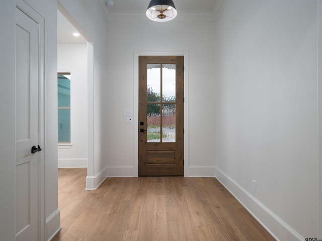 doorway to outside with light wood-type flooring and crown molding