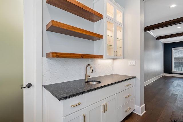 kitchen with white cabinets, sink, beamed ceiling, and dark wood-type flooring