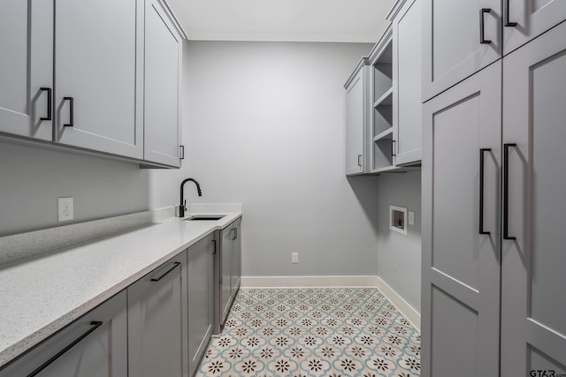 clothes washing area featuring cabinets, hookup for a washing machine, and sink