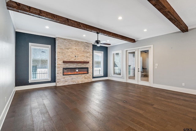 unfurnished living room with a fireplace, beam ceiling, dark hardwood / wood-style flooring, and plenty of natural light