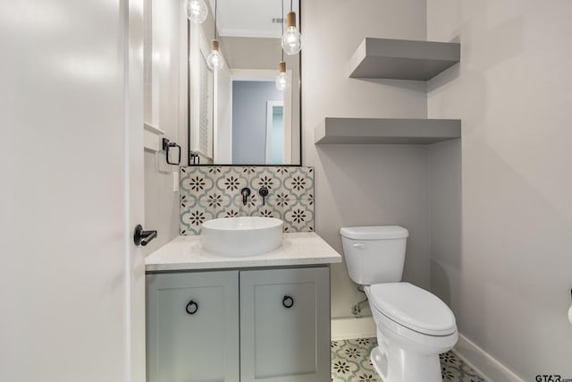 bathroom with vanity, toilet, and ornamental molding