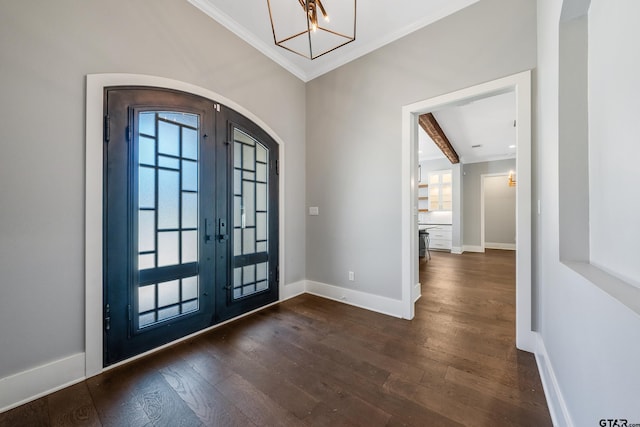 entrance foyer with french doors, ornamental molding, dark wood-type flooring, and a notable chandelier