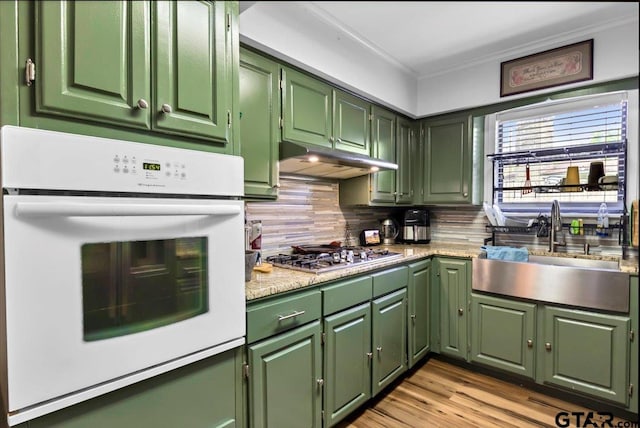 2631 Amy Ln, Tyler, TX 75701 - kitchen with green cabinetry, oven, stainless steel gas cooktop, crown molding, and tasteful backsplash
