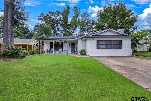 2631 Amy Ln, Tyler, TX 75701 - single story home with a front yard, a chimney, a porch, brick siding, and driveway