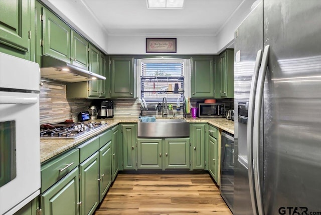 2631 Amy Ln, Tyler, TX 75701 - kitchen featuring stainless steel appliances, green cabinets, decorative backsplash, and crown molding