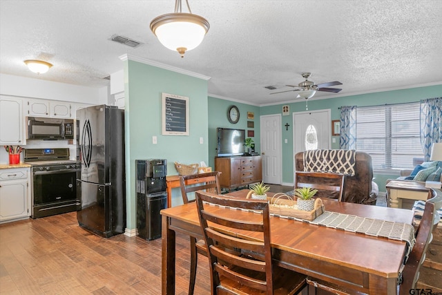 dining area featuring ornamental molding, a textured ceiling, ceiling fan, and light wood-type flooring