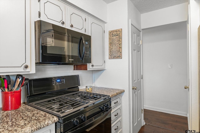 kitchen with black gas range oven, dark hardwood / wood-style floors, light stone countertops, white cabinets, and decorative backsplash