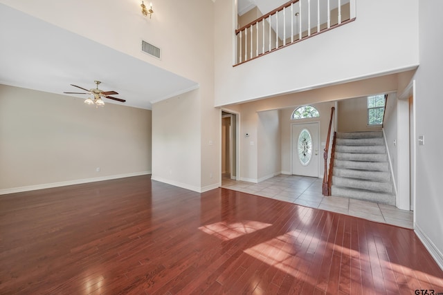 foyer entrance with visible vents, ceiling fan, hardwood / wood-style floors, and stairs