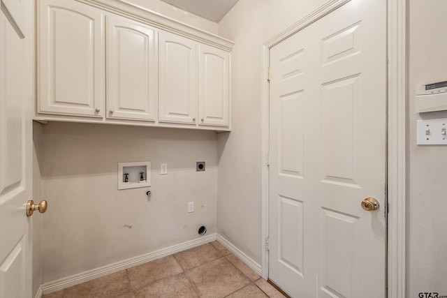 clothes washing area featuring electric dryer hookup, cabinet space, washer hookup, baseboards, and light tile patterned flooring