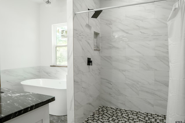 1605 County Road 4510, Winnsboro, TX 75494 - full bathroom with tile walls, a stall shower, wainscoting, a soaking tub, and vanity