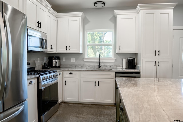 1605 County Road 4510, Winnsboro, TX 75494 - kitchen with appliances with stainless steel finishes, a sink, white cabinetry, and light stone counters