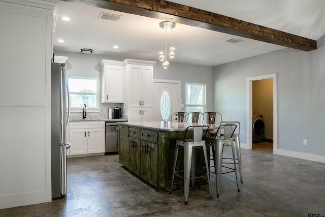 1605 County Road 4510, Winnsboro, TX 75494 - kitchen featuring washer / dryer, stainless steel appliances, finished concrete floors, a kitchen bar, and a kitchen island