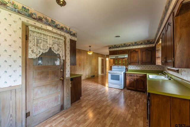 138 Drexel Dr, Sulphur Springs, TX 75482 - kitchen with white range with electric cooktop, wallpapered walls, under cabinet range hood, a sink, and light wood-style floors