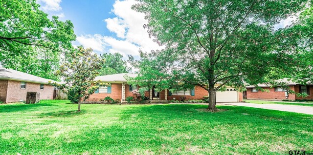 138 Drexel Dr, Sulphur Springs, TX 75482 - view of front of house featuring driveway, a garage, brick siding, and a front lawn