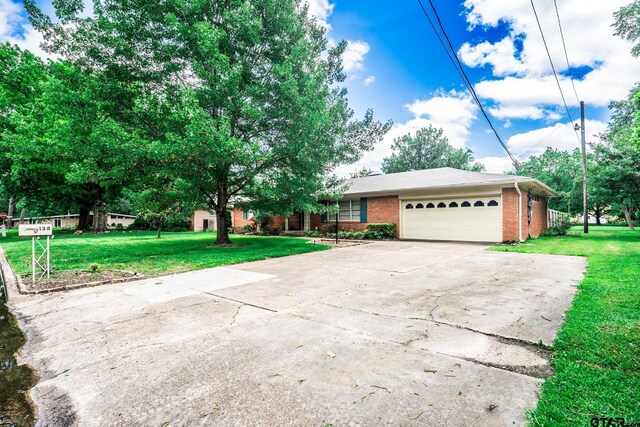 138 Drexel Dr, Sulphur Springs, TX 75482 - view of front of property featuring a garage, brick siding, concrete driveway, and a front lawn