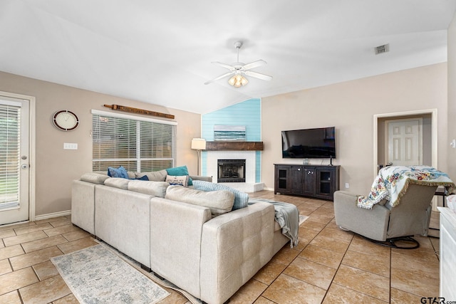 living room with a large fireplace, ceiling fan, and vaulted ceiling