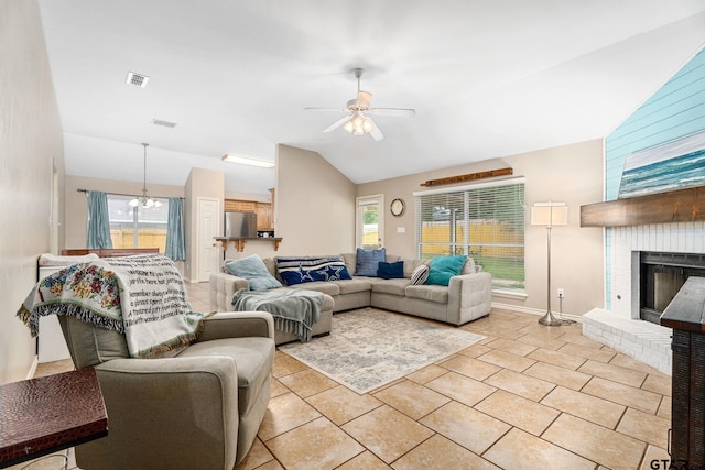 living room featuring a fireplace, ceiling fan, light tile patterned floors, and vaulted ceiling