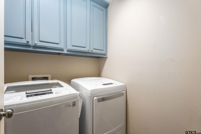 washroom with cabinets and washer and dryer