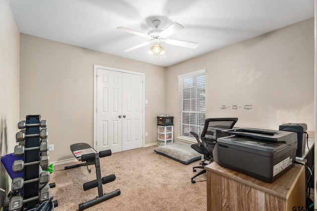 carpeted home office featuring ceiling fan