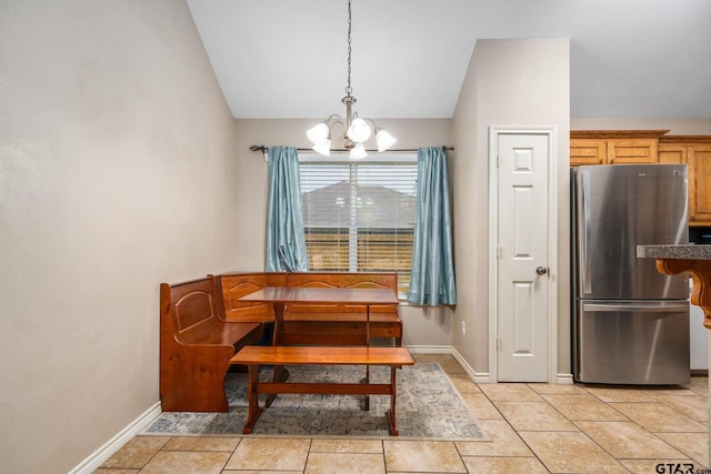 dining space featuring vaulted ceiling and a notable chandelier