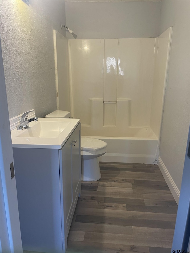 full bathroom featuring hardwood / wood-style flooring, toilet, vanity, and  shower combination