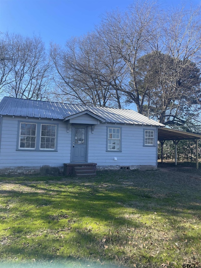 view of front of home with a front yard and a carport