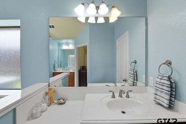 3029 Yasmeen Cir, Flint, TX 75762 - bathroom featuring vanity, a chandelier, healthy amount of natural light, and a textured wall