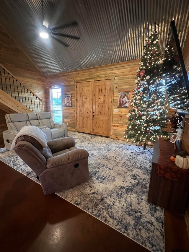 living room with ceiling fan, wood walls, and lofted ceiling