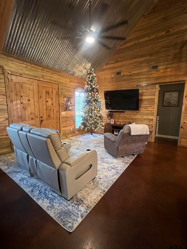 living room with high vaulted ceiling, ceiling fan, and wood walls