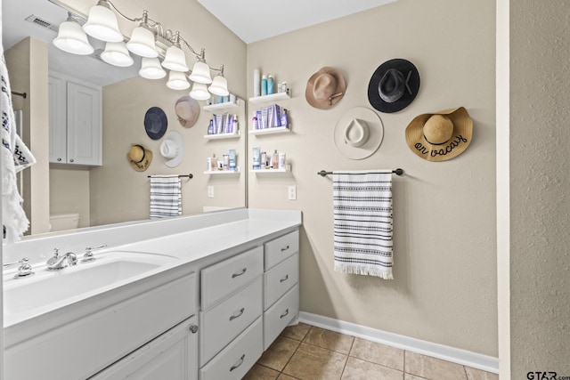 bathroom featuring toilet, vanity, and tile patterned flooring