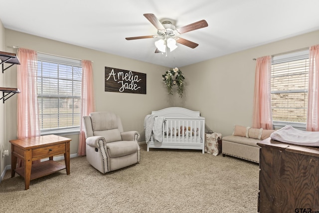 bedroom featuring ceiling fan, carpet flooring, and a nursery area