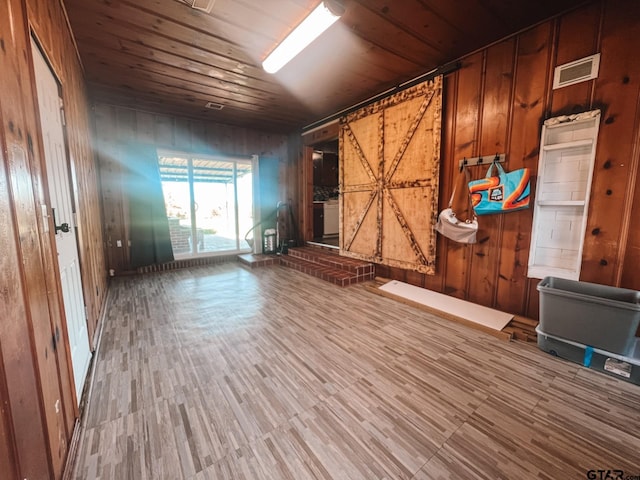 spare room with wooden walls, hardwood / wood-style flooring, and wooden ceiling