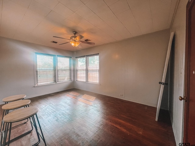 unfurnished room featuring dark wood-type flooring and ceiling fan