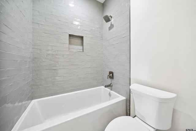 bathroom featuring toilet and tiled shower / bath