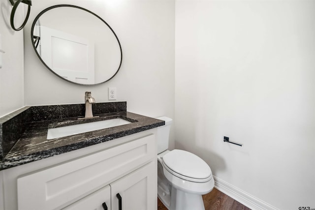 bathroom featuring toilet, vanity, and hardwood / wood-style flooring