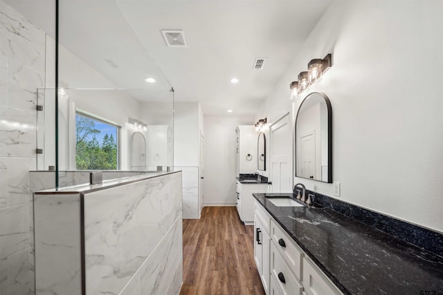 bathroom featuring a tile shower, vanity, and hardwood / wood-style flooring