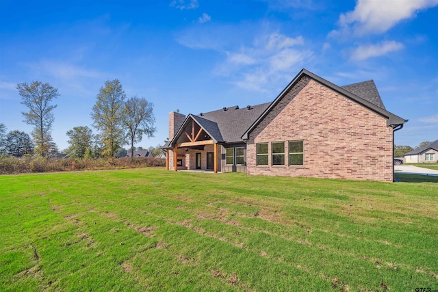 rear view of property featuring a lawn