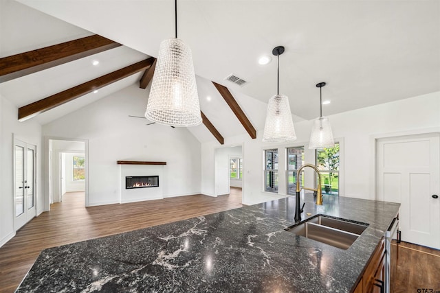 kitchen featuring vaulted ceiling with beams, plenty of natural light, hanging light fixtures, and sink