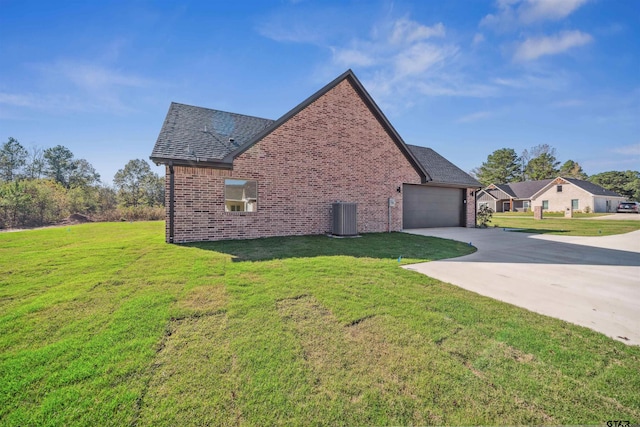 view of side of property with a yard, a garage, and central AC unit