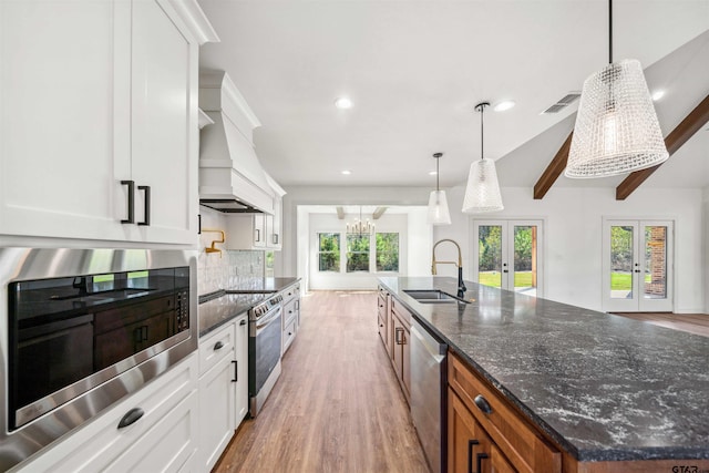 kitchen with french doors, sink, a large island, white cabinetry, and stainless steel appliances