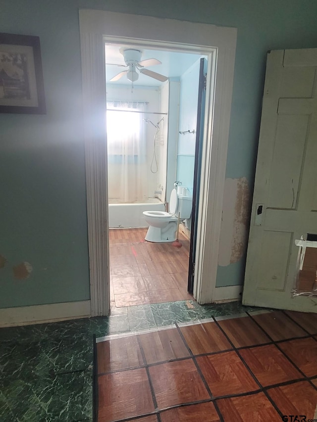 bathroom featuring toilet, tub / shower combination, and ceiling fan